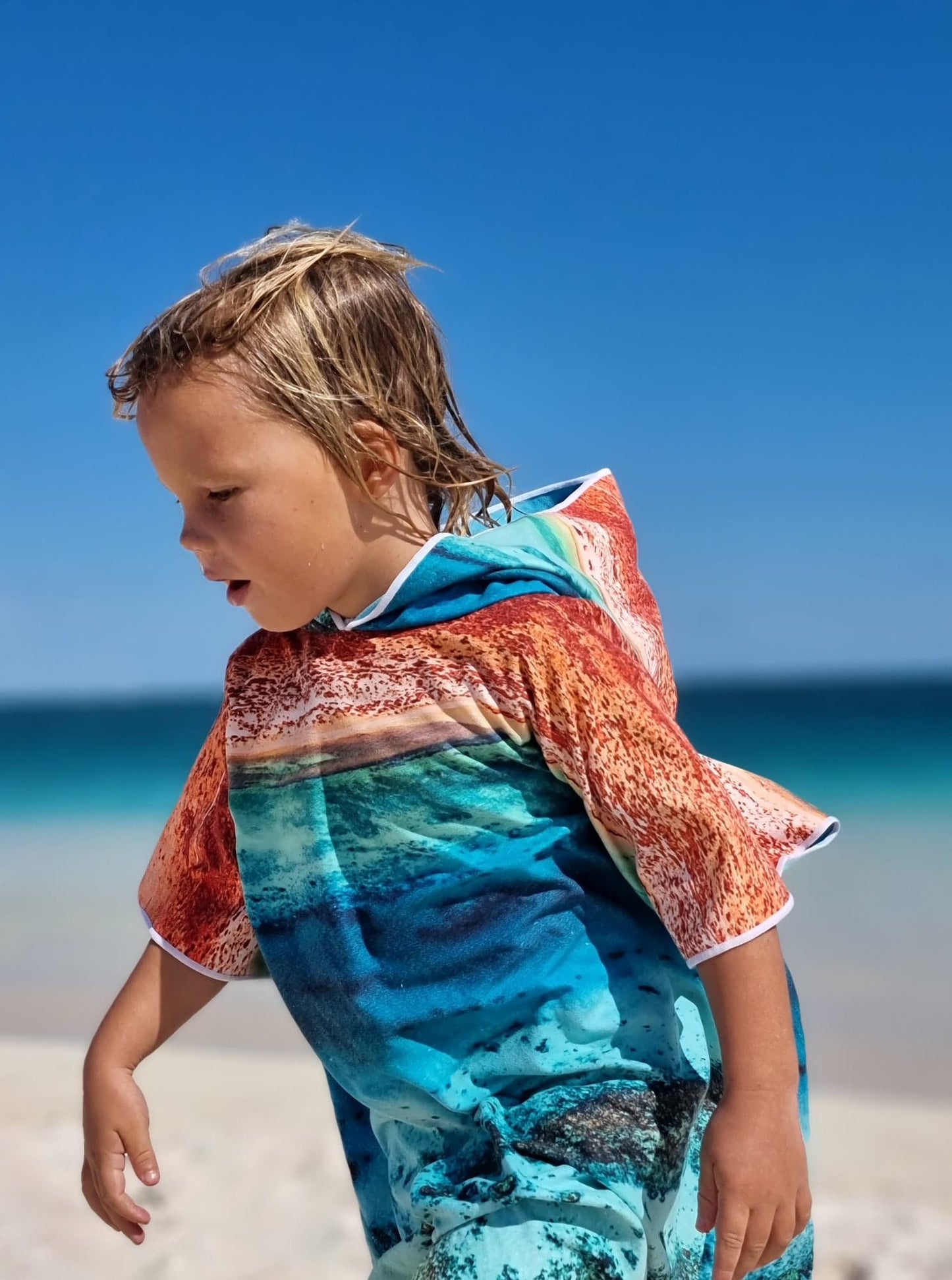Mini Ningaloo HoodedQuick Dry Kids Hooded TowelFor the beach, travelling, camping, swimming lessons and more!Sustainably made using post-consumer plastic bottles in the form of recycled Polyester (rPET) Exclusive design by Violeta Brosig of Blue Media ExmouthInspired by the rugged red ranges meeting the pristine waters of the Ningaloo Coasts fringing reef, just meters from the shore.$57.99Will and Wind