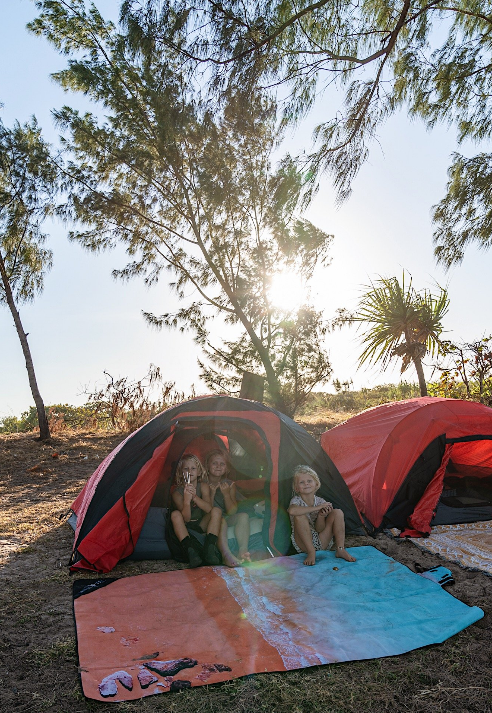 Kimberley Beach MatExclusive design by Trip In A VanThe Kimberley; Inspired by the turquoise blues and red pindan sands of Roebuck Bay, Broome WA FINALLY a mat you can throw down anywhere, anytime! The top side of our beach mats are made from an exceptionally durable, hard-wearing, yet soft feeling Oxford fabric. The rugged versatility of this material is perfect for outdoor conditions due to its water and mildew resistant qualities. Watch the spilt drinks bead off, and wipe clean for an instant dry feeling