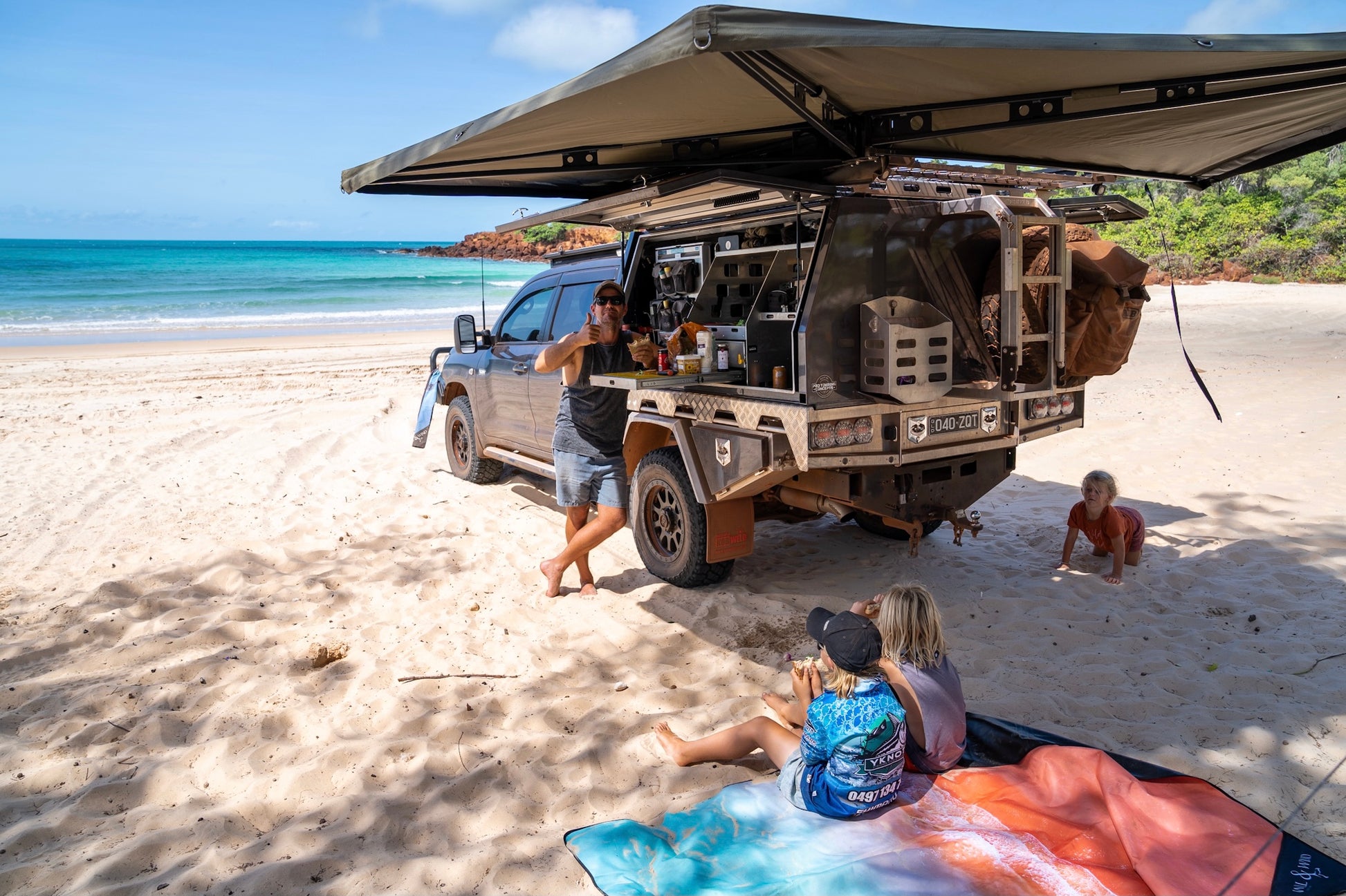 Kimberley Beach MatExclusive design by Trip In A VanThe Kimberley; Inspired by the turquoise blues and red pindan sands of Roebuck Bay, Broome WA FINALLY a mat you can throw down anywhere, anytime! The top side of our beach mats are made from an exceptionally durable, hard-wearing, yet soft feeling Oxford fabric. The rugged versatility of this material is perfect for outdoor conditions due to its water and mildew resistant qualities. Watch the spilt drinks bead off, and wipe clean for an instant dry feeling